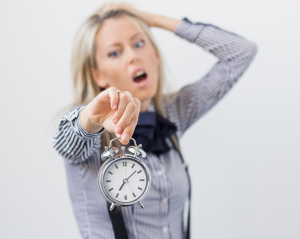 Stressful and frustrated woman holding alarm clock
